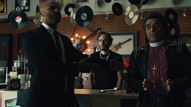 Shadow and Wednesday robbing a music shop by pretending to be an FBI agent and a con man pretending to be a bishop.